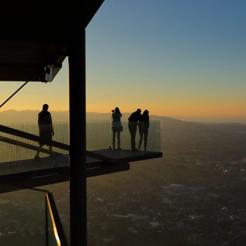 Menschen blicken bei Sonnenuntergang von der Aussichtsplattform Karren über Dornbirn