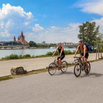 Paar fährt Fahrrad an Uferwegen Donauinsel in Wien